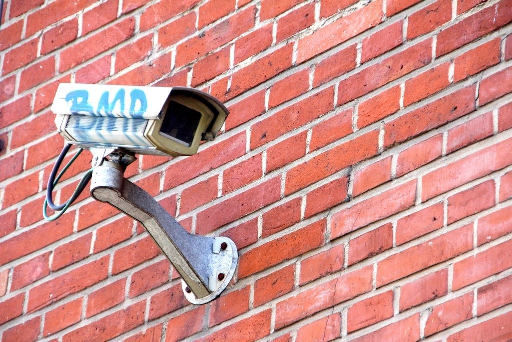 Outdoor CCTV camera installed on a red-brick wall