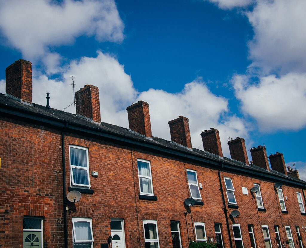 Red-brick terraced houses with chimneys in Manchester