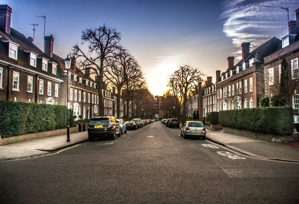 Live-style camera view of a UK residential street of brick terraced houses at sunset